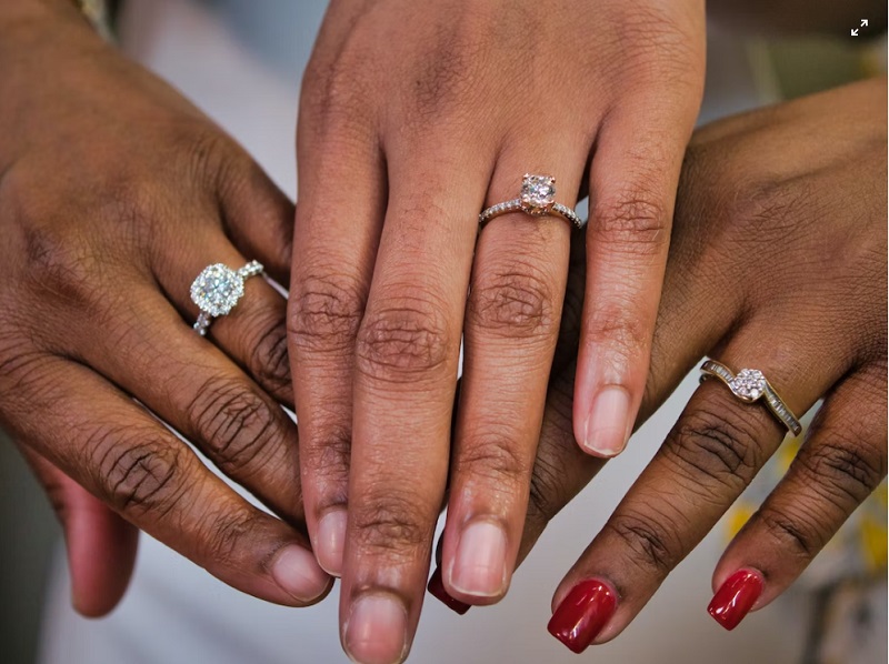 Three women's hands each with a diamond engagement ring