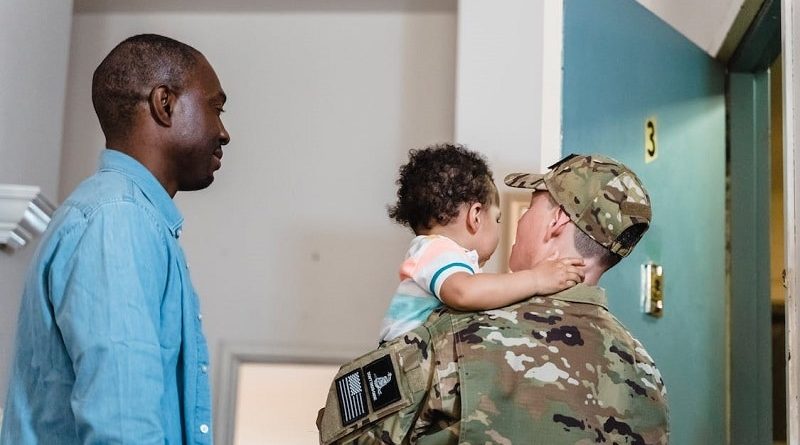 Veteran Parents: 4 things you should know / Two men one in a blue shirt and the other in military fatigues who is holding a small toddler