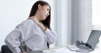 Woman with shoulder pain working at her office desk