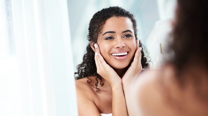 Beautiful Woman with Glowing Skin Looking Into a Mirror