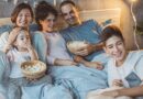 12 Family Bonding Ideas to Bring Your Family Closer Together / Family having an in home movie night with bowls of popcorn