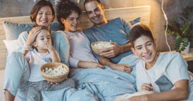 12 Family Bonding Ideas to Bring Your Family Closer Together / Family having an in home movie night with bowls of popcorn