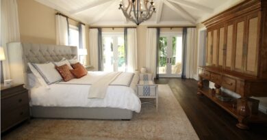 10 Ways To Snazz Up Your Ceilings / Neutral Bedroom with a Large Upholstered Headboard, French Doors, and a Custom Ceiling and Light Fixture