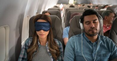 Couple Sleeping on a Plane. She is wearing a sleep mask, and he has on headphones