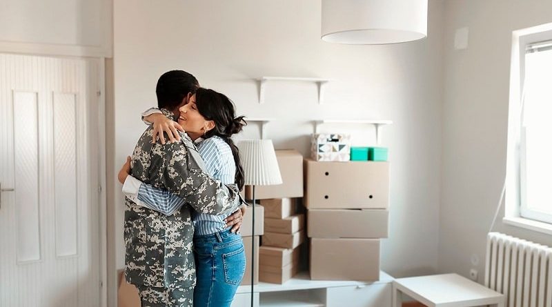First-Time Homebuyer in Washington State / Couple hugging in their new home, surround by packed boxes