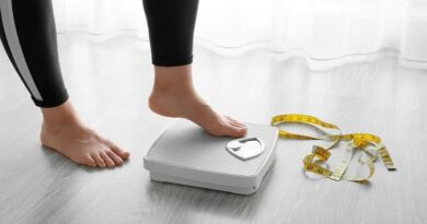 How To Sabotage Your Weight Loss Goals / Woman stepping on a scale with a measureing tape next to the scale