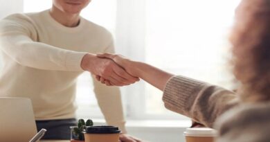 Starting a Franchise / Man and woman shaking hands across a desk