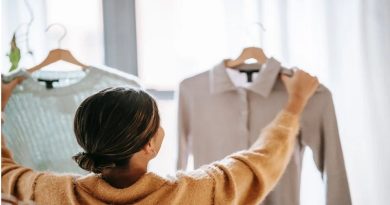 Determining Where You Sit In The Market, And What That Means / Woman holding up and looking at two different tops on hangers