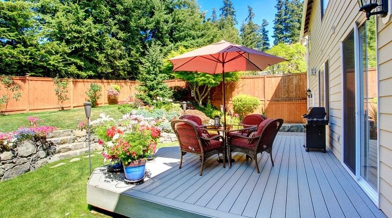 Outdoor Entertainment Area / Backyard Deck with Rattan Chairs a Table Umbrella and BBQ Grill