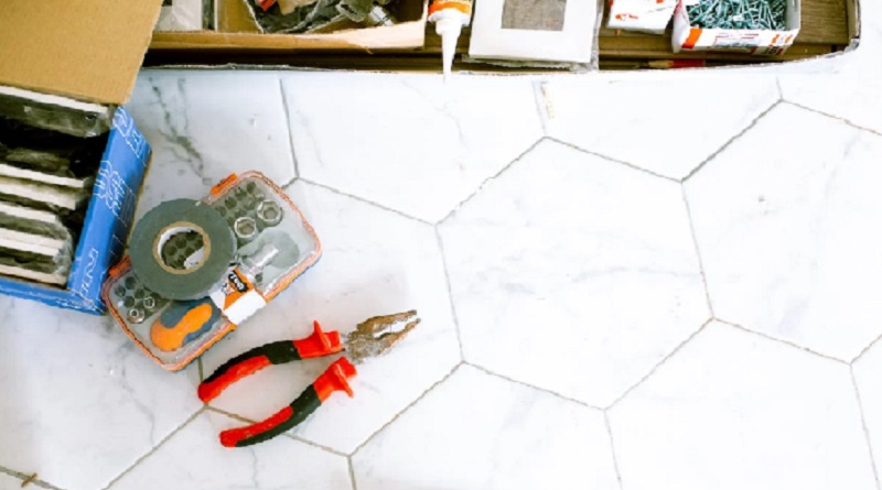Tools and nails laid out on a tile counter