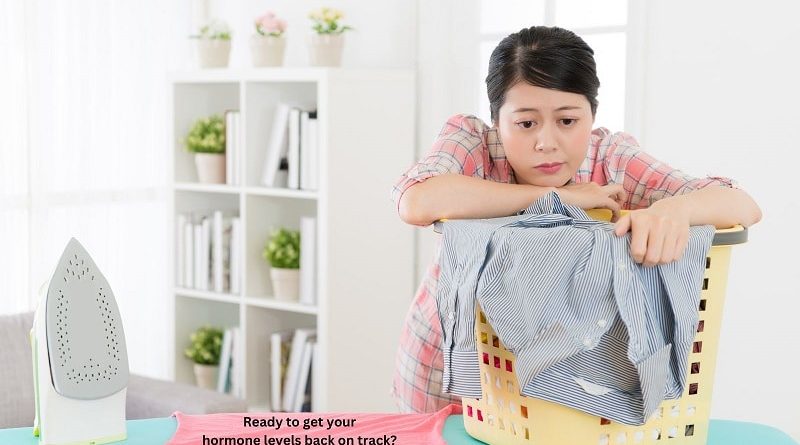 Low Hormone Levels / Tired woman leaning over a filled laundry basket