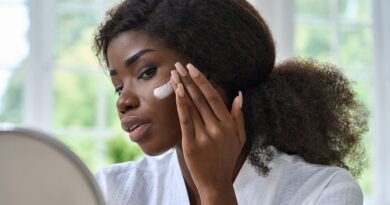 Skincare Mistakes / Woman sitting in front of a mirror, putting on skin cream