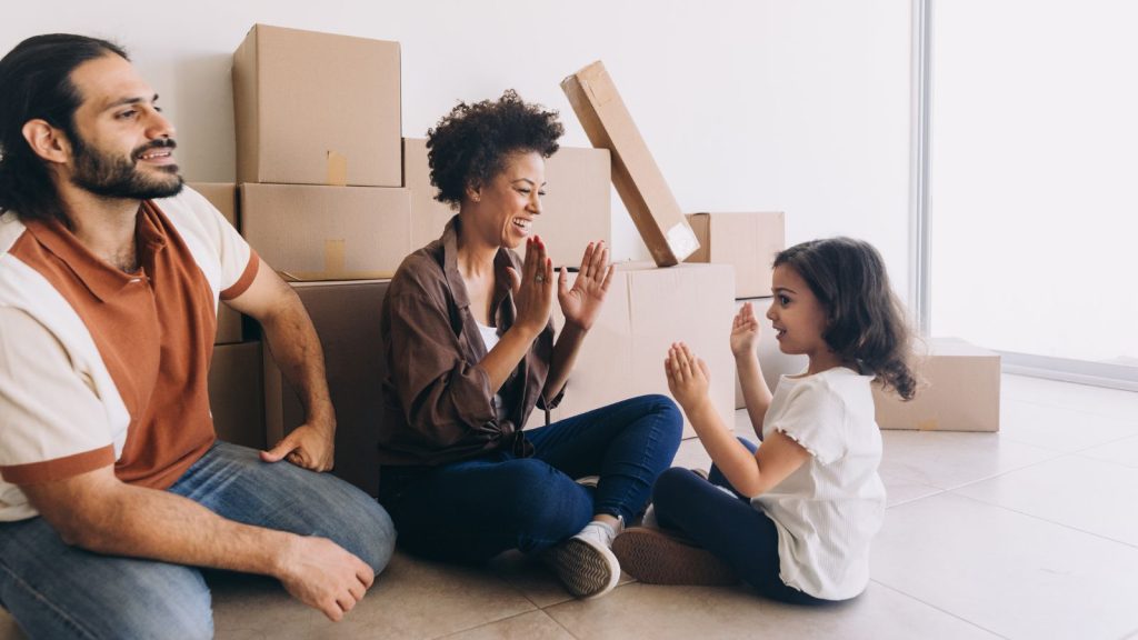 YoLiving in Caledon / Young family sitting in front of packed boxes for a move