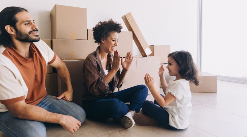 YoLiving in Caledon / Young family sitting in front of packed boxes for a move