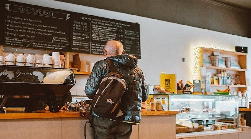 The Best Ways to Wow Your Customers and Keep Them Coming Back / Man ordering at the counter in a coffee shop