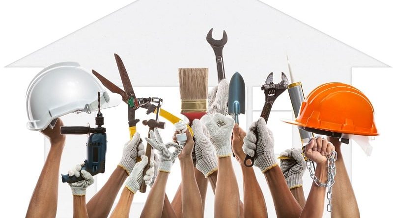 Raised Arms with Gloved Hands Holding up Tools and Hardhats