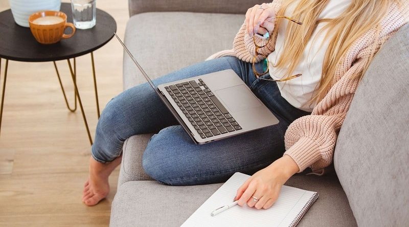 Woman sitting on her sofa with a laptop on her lap