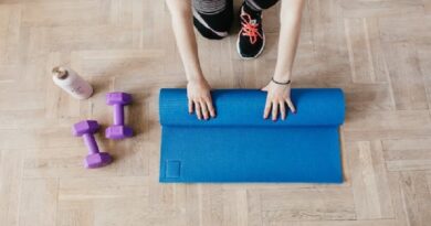 Woman rolling out an exercise mat. / Healthy Lifestyle
