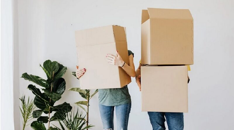 Couple holding moving boxes in a room with plants / 7 TIPS FOR A SMOOTH MOVE FROM WEST PALM BEACH