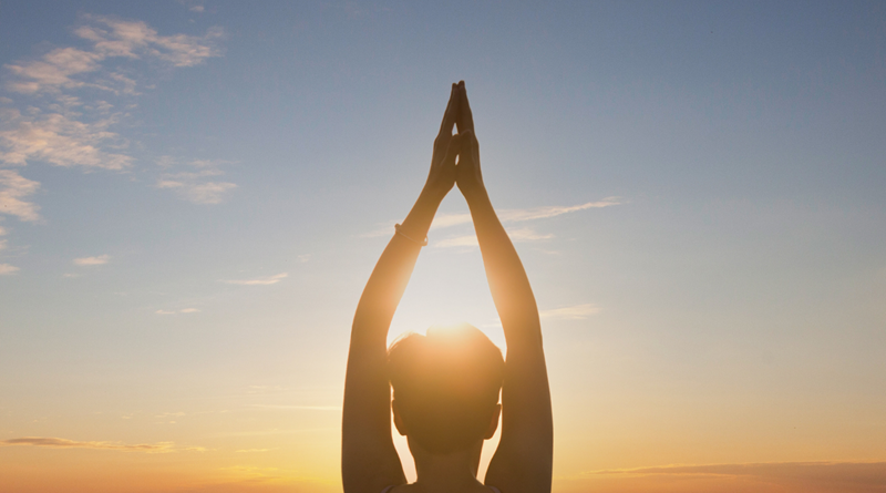 Woman practicing Yoga at Sunrise