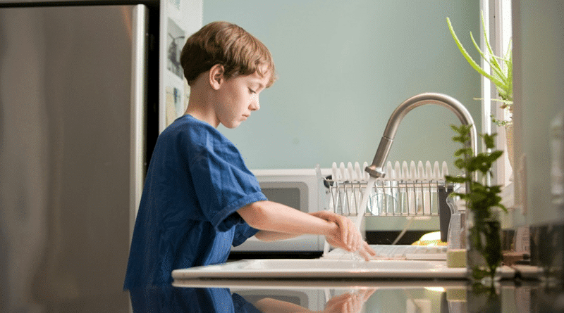 Young Boy Washing His Hands at the Kitchen Sink