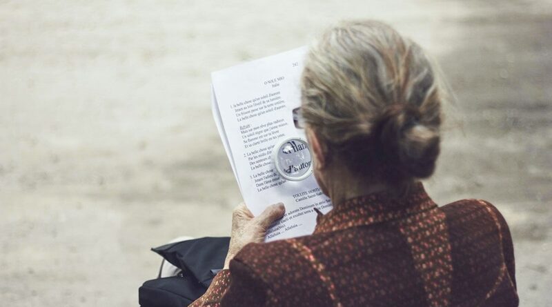 Elderly Woman Reading a Form with a Magnifiying Glass