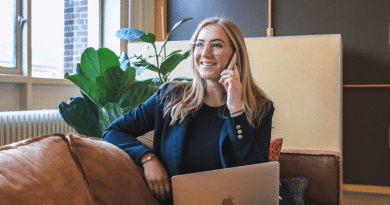 Woman talking on her phone with a an open laptop /