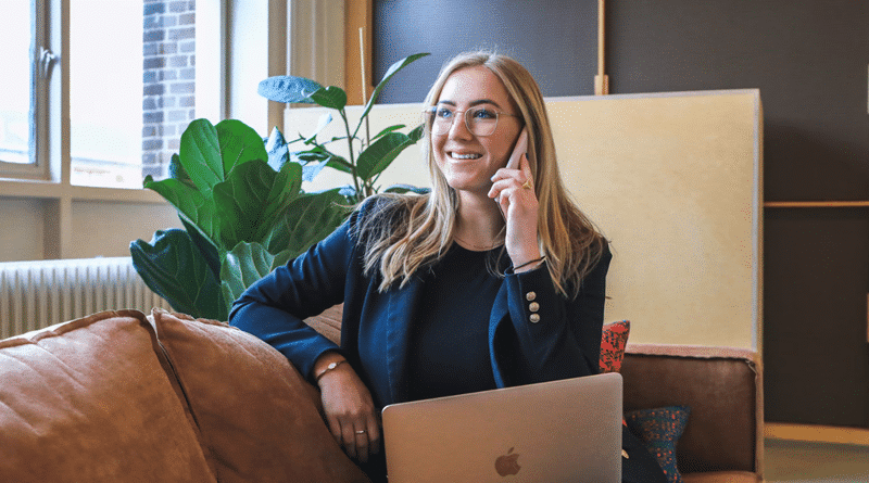 Woman talking on her phone with a an open laptop /