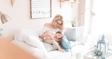 Woman snuggling with a young child on a white sofa with blue stiped pillows / How To Make Your Home A Happier, Healthier Place