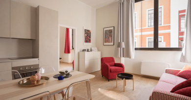 apartment with large windows and red accents / Apartment Living 101: A Living Room Facelift The Easy Way