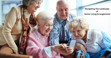 4 well dressed senior citizens looking at the screen of a smart phone / Navigating The Landscape of Senior Living Arrangements
